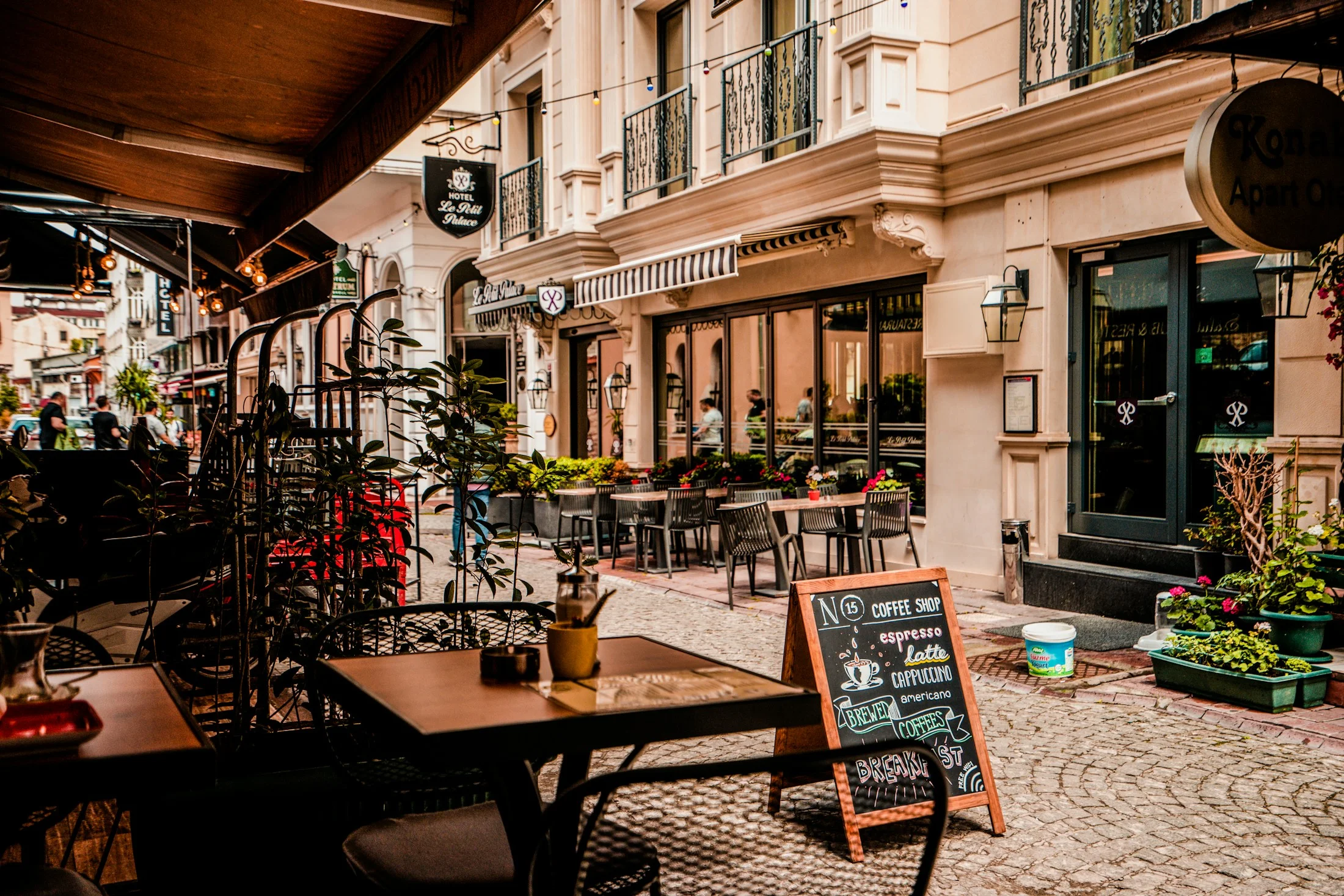La terrazza di un caffè, con tavoli e sedie lungo una strada pedonale
